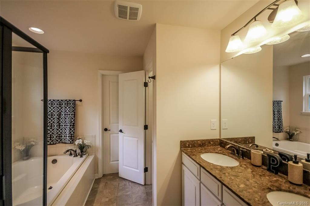 7700 West Berkeley Road Denver, NC 28037 - Photo 13 of 24 a bathroom with a granite countertop tub sink and mirror