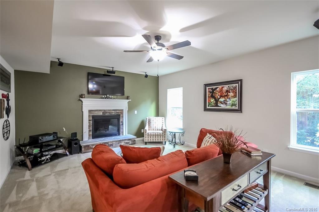 7700 West Berkeley Road Denver, NC 28037 - Photo 3 of 24 a living room with furniture a fireplace and a flat screen tv