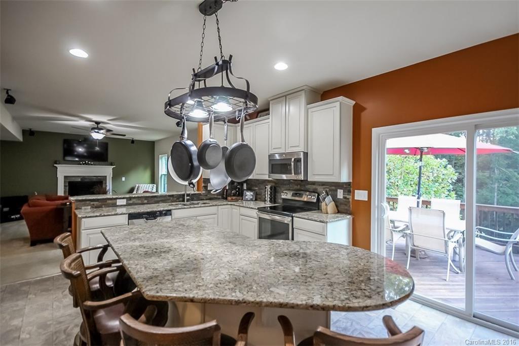 7700 West Berkeley Road Denver, NC 28037 - Photo 5 of 24 a kitchen with stainless steel appliances granite countertop a stove a refrigerator a sink with a dining table and chairs
