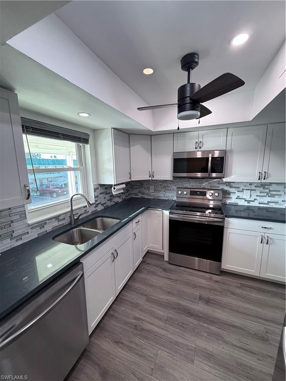 a large kitchen with stainless steel appliances granite countertop a stove sink and cabinets