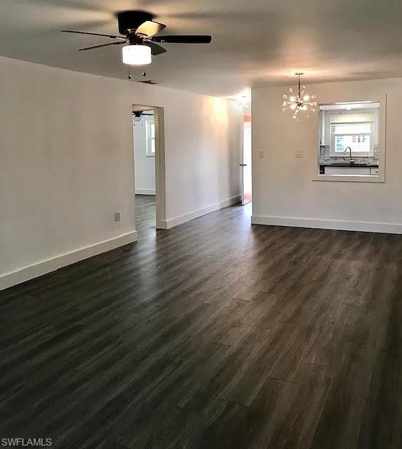 200 Valley Stream Drive, Unit 8B Naples, FL 34113 - Photo 4 of 15 This living area features dark wood-style flooring, white walls, and a contemporary ceiling fan with an integrated light fixture