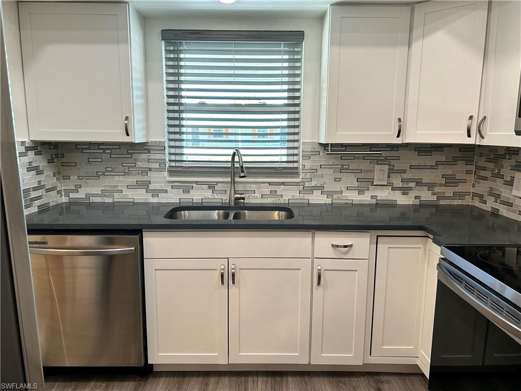 200 Valley Stream Drive, Unit 8B Naples, FL 34113 - Photo 5 of 21 a kitchen with granite countertop cabinets and white appliances