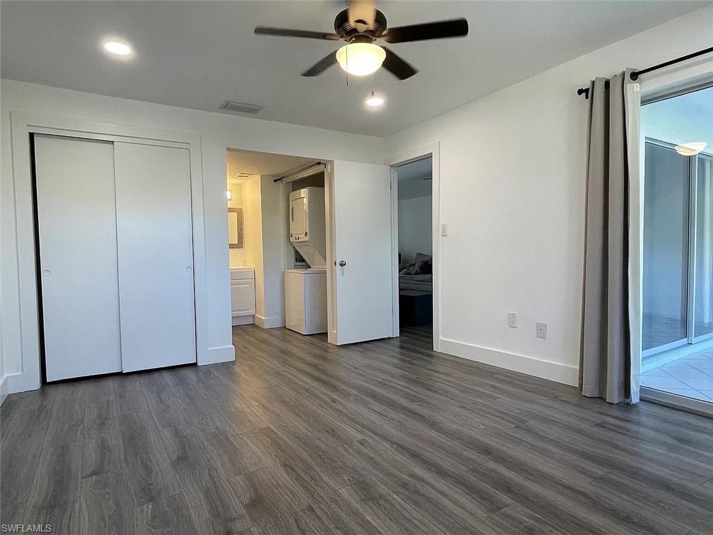 200 Valley Stream Drive, Unit 8B Naples, FL 34113 - Photo 6 of 15 The property features a spacious room with wood-style flooring, a ceiling fan with integrated lighting, and a large sliding glass door