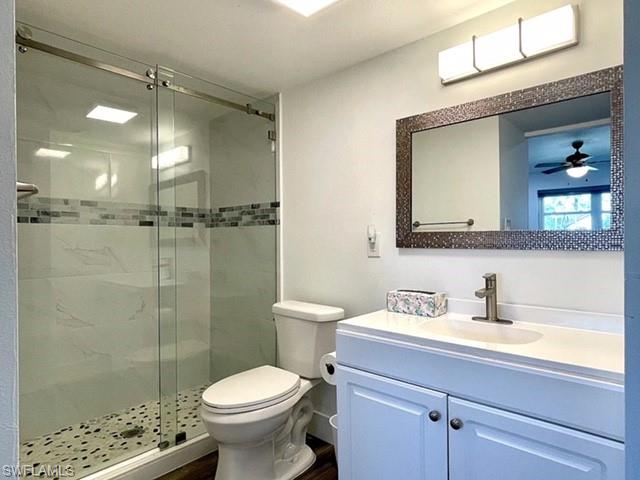 200 Valley Stream Drive, Unit 8B Naples, FL 34113 - Photo 10 of 15 Bathroom featuring a shower with sliding glass doors, mosaic tile accent band, and a pebble-tiled floor