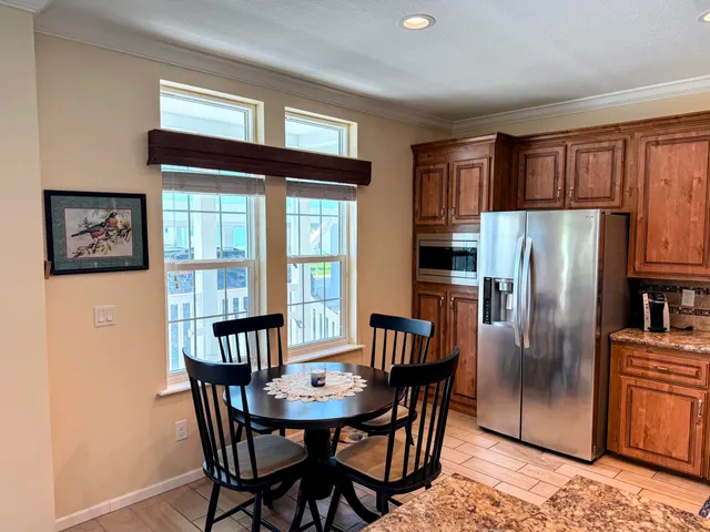 a view of a dining room with furniture a kitchen and chandelier