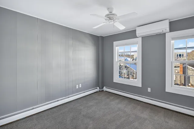 an empty room with windows and fan