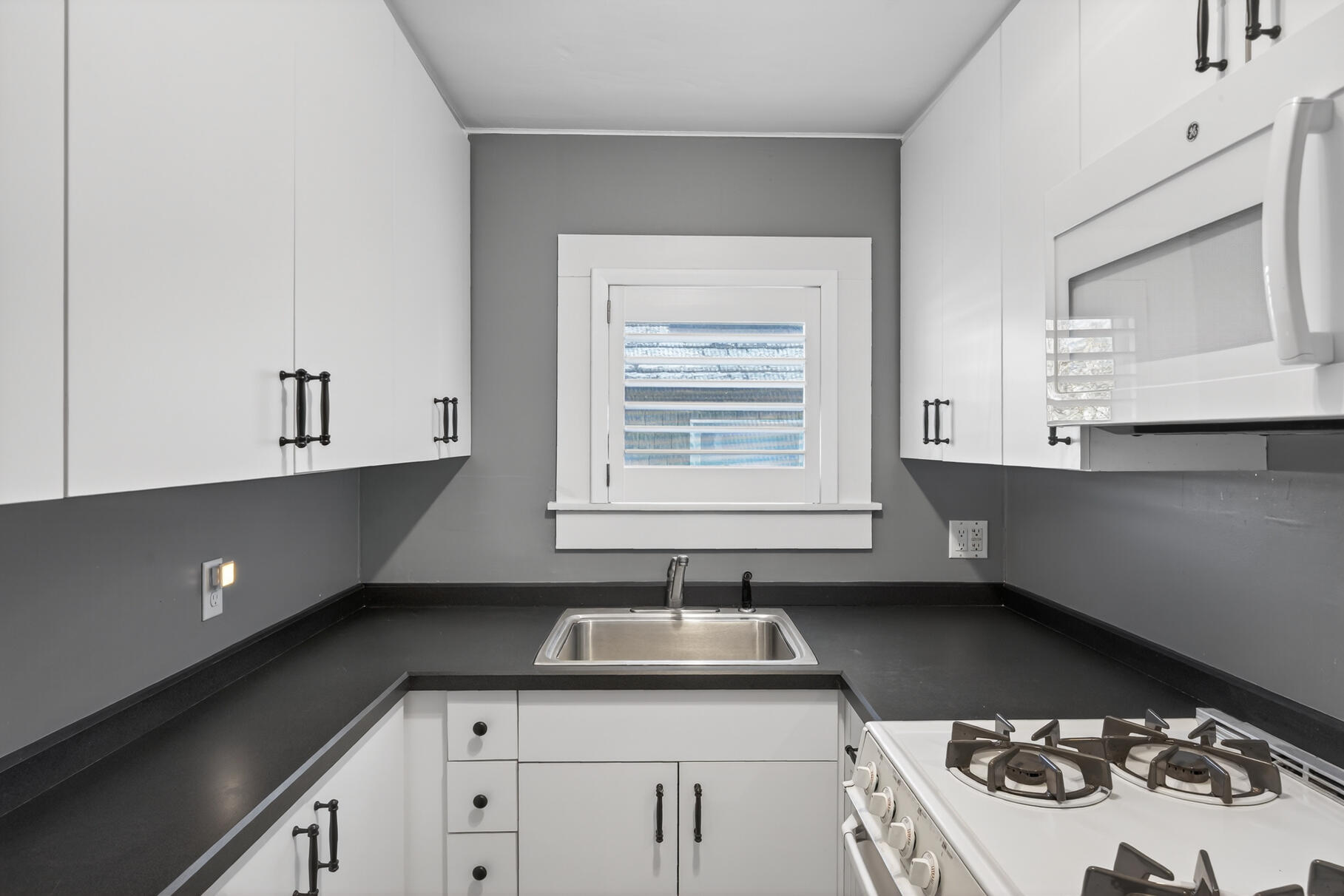 539 Commercial Street, Unit 3 Provincetown, MA 02657 - Photo 6 of 29 a kitchen with a sink stove and cabinets