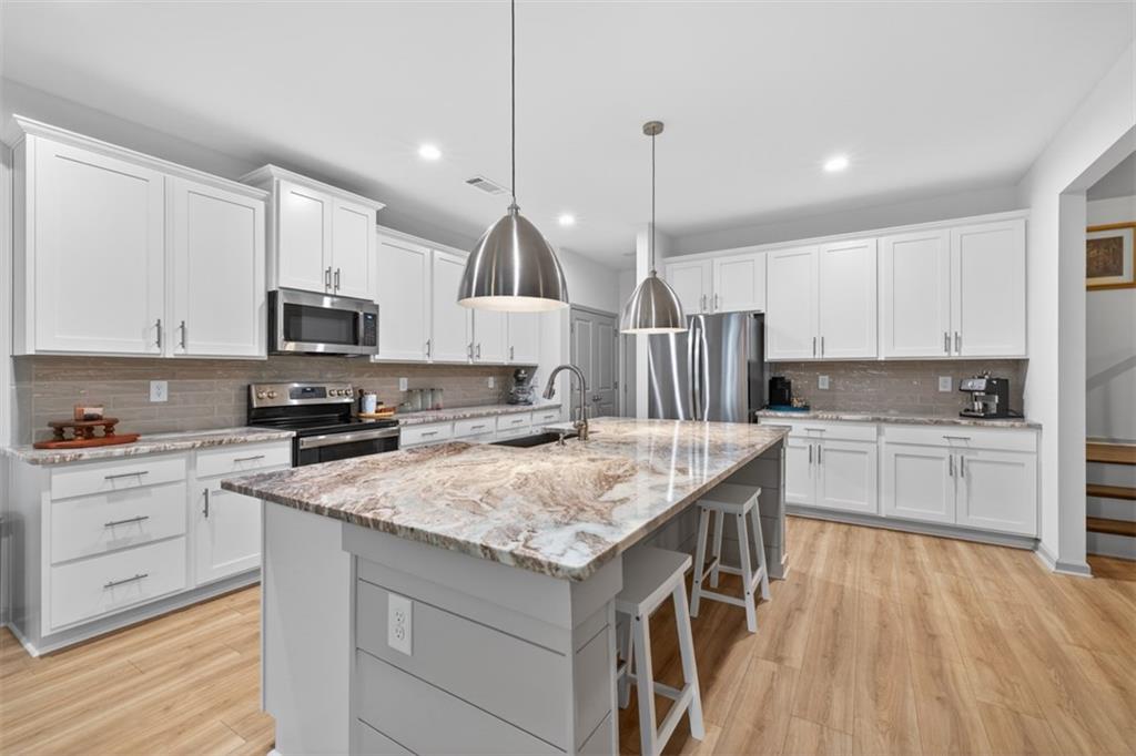 311 Rockwell Church Road Northwest Winder, GA 30680 - Photo 11 of 55 a kitchen with a sink center island stainless steel appliances and cabinets