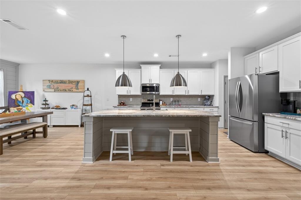 311 Rockwell Church Road Northwest Winder, GA 30680 - Photo 12 of 55 a large kitchen with stainless steel appliances kitchen island granite countertop a refrigerator a stove a sink and a oven