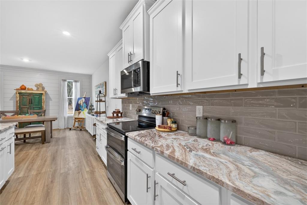 311 Rockwell Church Road Northwest Winder, GA 30680 - Photo 15 of 55 a kitchen with stainless steel appliances granite countertop a stove and white cabinets
