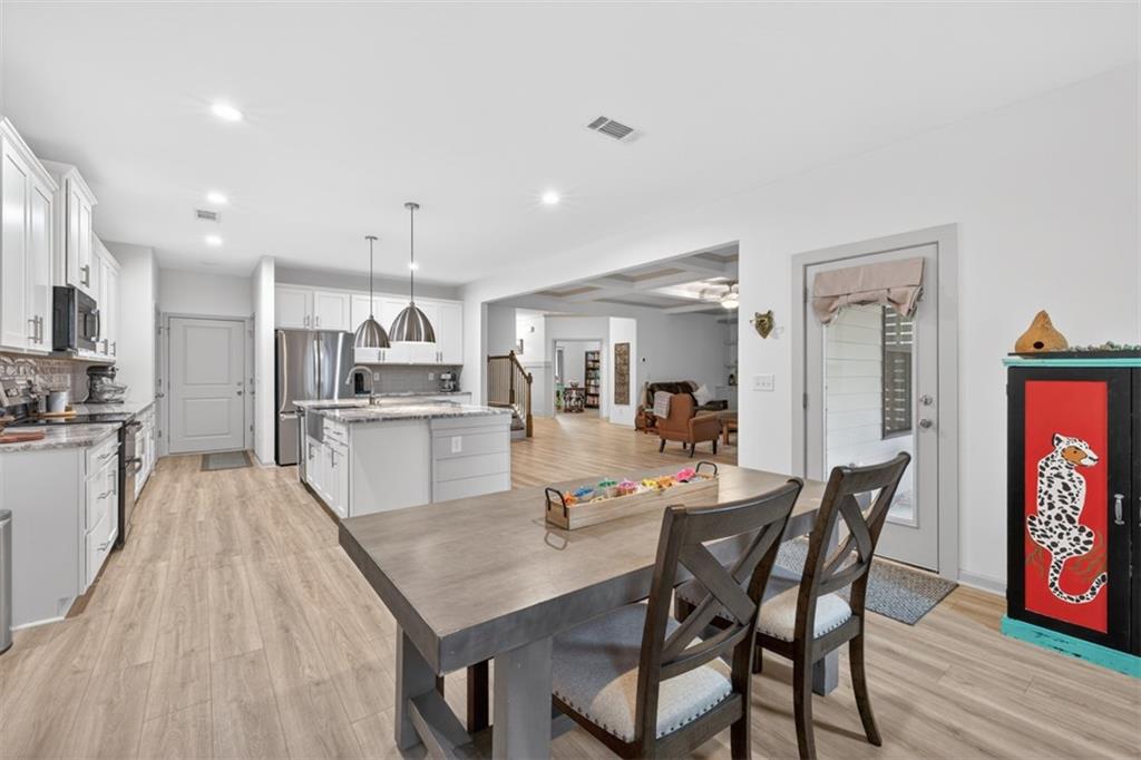 311 Rockwell Church Road Northwest Winder, GA 30680 - Photo 18 of 55 a kitchen with stainless steel appliances granite countertop a kitchen island a stove a table and chairs