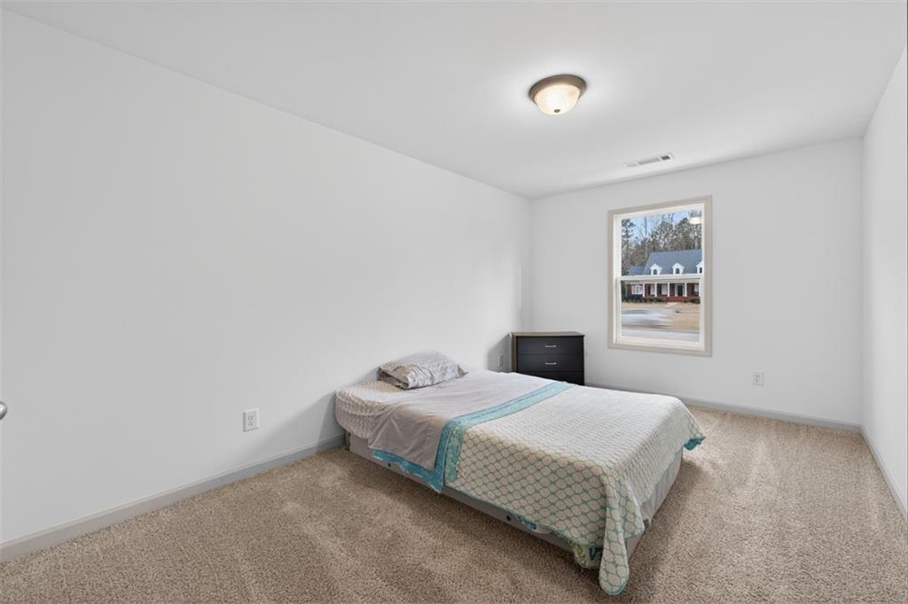 311 Rockwell Church Road Northwest Winder, GA 30680 - Photo 21 of 55 a bedroom with a bed and a wall painting