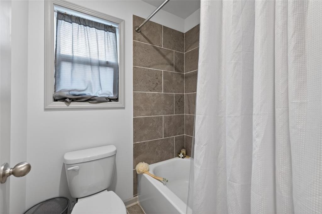311 Rockwell Church Road Northwest Winder, GA 30680 - Photo 23 of 55 a bathroom with a toilet and a shower curtain