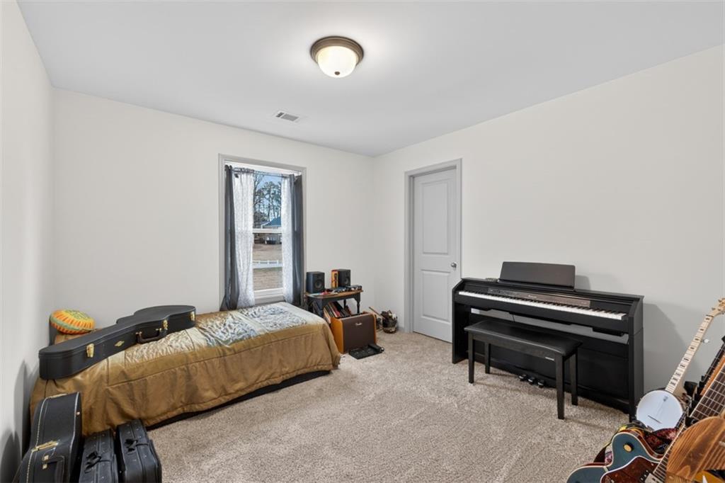 311 Rockwell Church Road Northwest Winder, GA 30680 - Photo 29 of 55 a bedroom with a bed and a piano