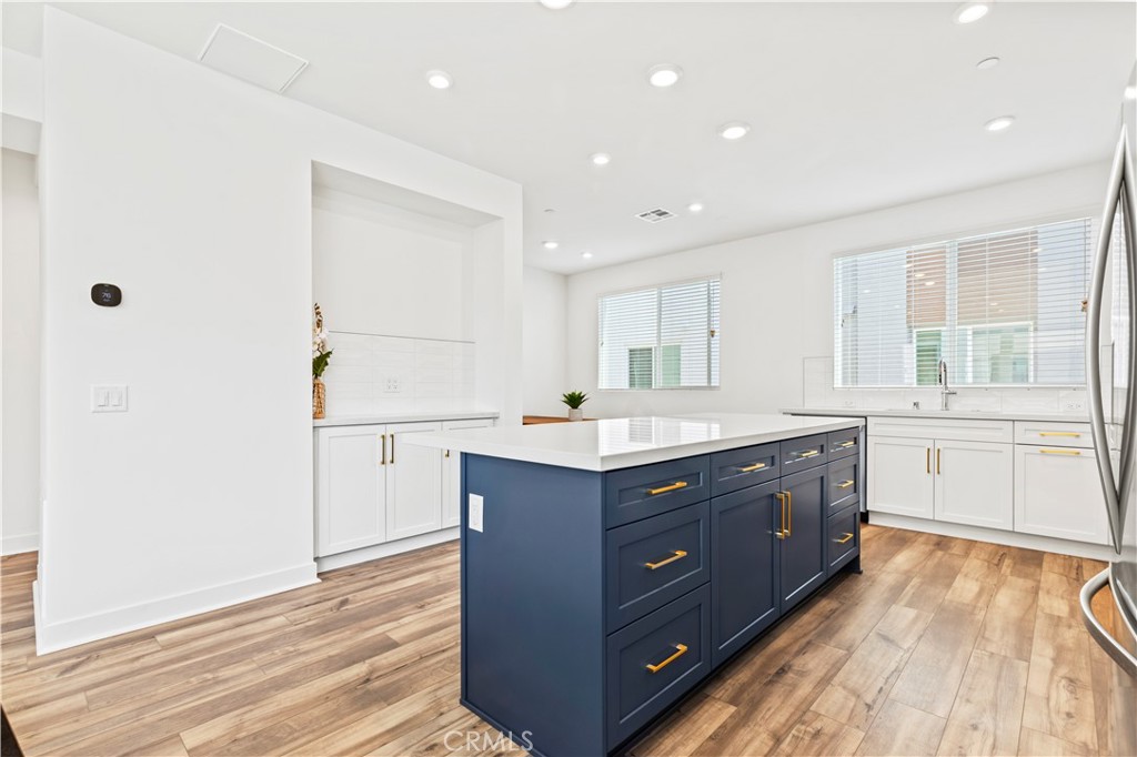 609 South Lyon Street Santa Ana, CA 92705 - Photo 15 of 36 a room with a wooden floor and white cabinets