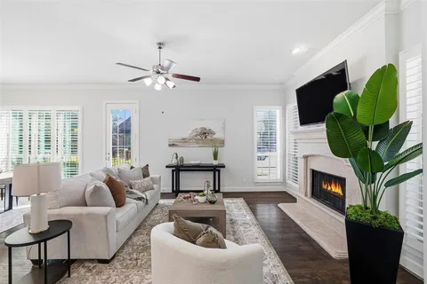 a living room with furniture a fireplace a chandelier and a window