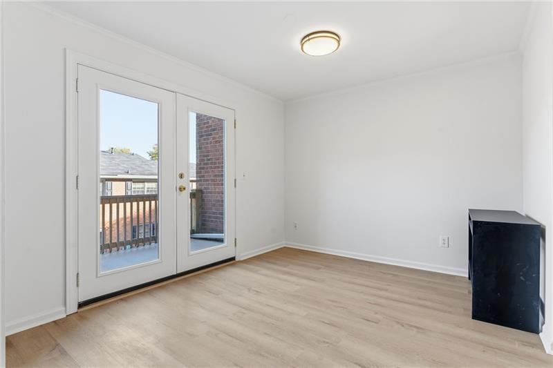 6520 Roswell Road, Unit 79 Atlanta, GA 30328 - Photo 11 of 23 an empty room with wooden floor and windows