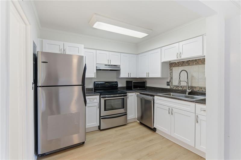 6520 Roswell Road, Unit 79 Atlanta, GA 30328 - Photo 12 of 23 a kitchen with granite countertop a refrigerator sink and stove