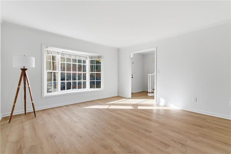 6520 Roswell Road, Unit 79 Atlanta, GA 30328 - Photo 7 of 23 a view of an empty room with wooden floor and a window
