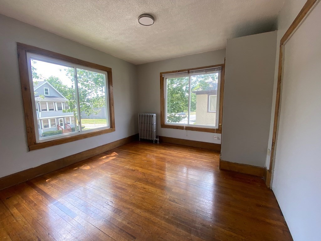 331-335 Allen Street Springfield, MA 01108 - Photo 4 of 8 a view of an empty room with wooden floor and a window