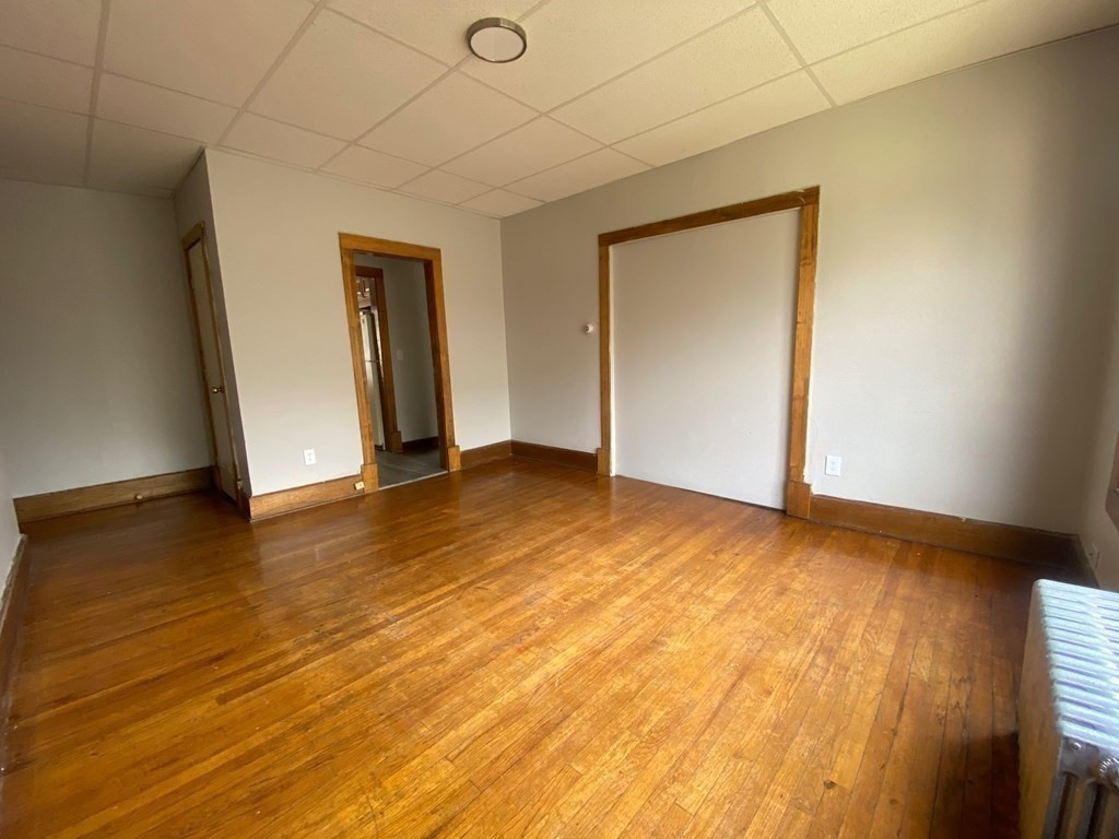 331-335 Allen Street Springfield, MA 01108 - Photo 6 of 8 a view of an empty room with wooden floor and a window