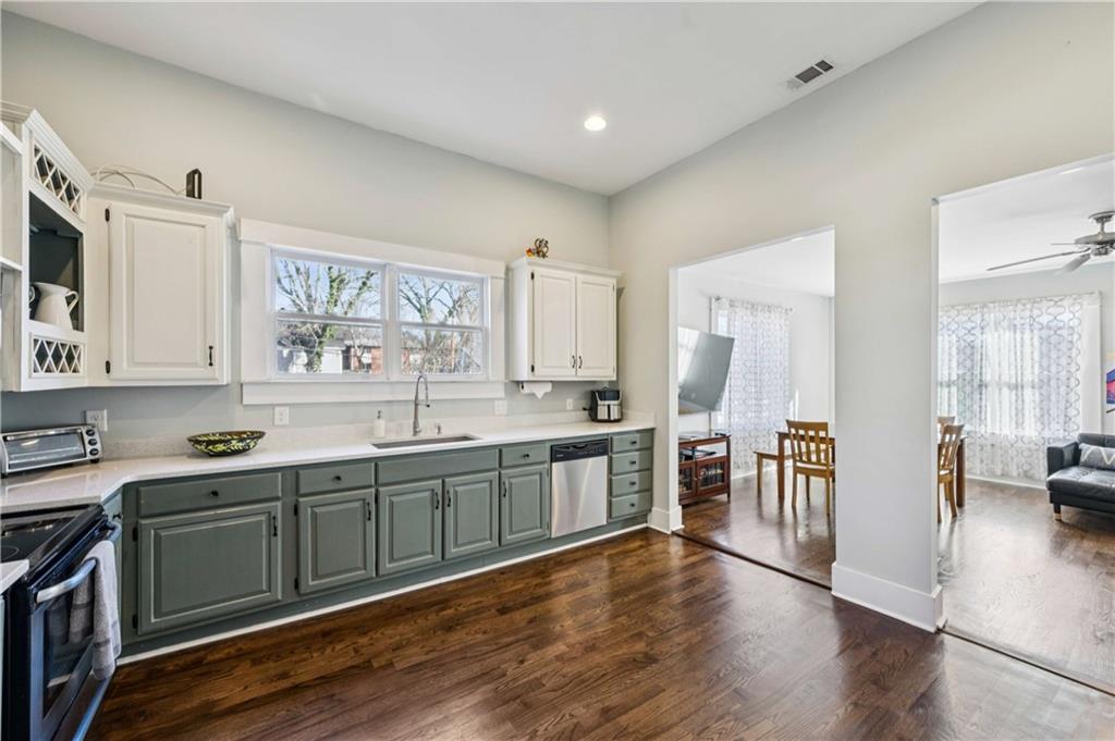 528 Holderness Street Southwest Atlanta, GA 30310 - Photo 12 of 42 a large kitchen with a large counter top space a sink stainless steel appliances and cabinets