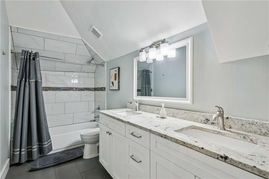 528 Holderness Street Southwest Atlanta, GA 30310 - Photo 16 of 42 a bathroom with a granite countertop sink a toilet and shower