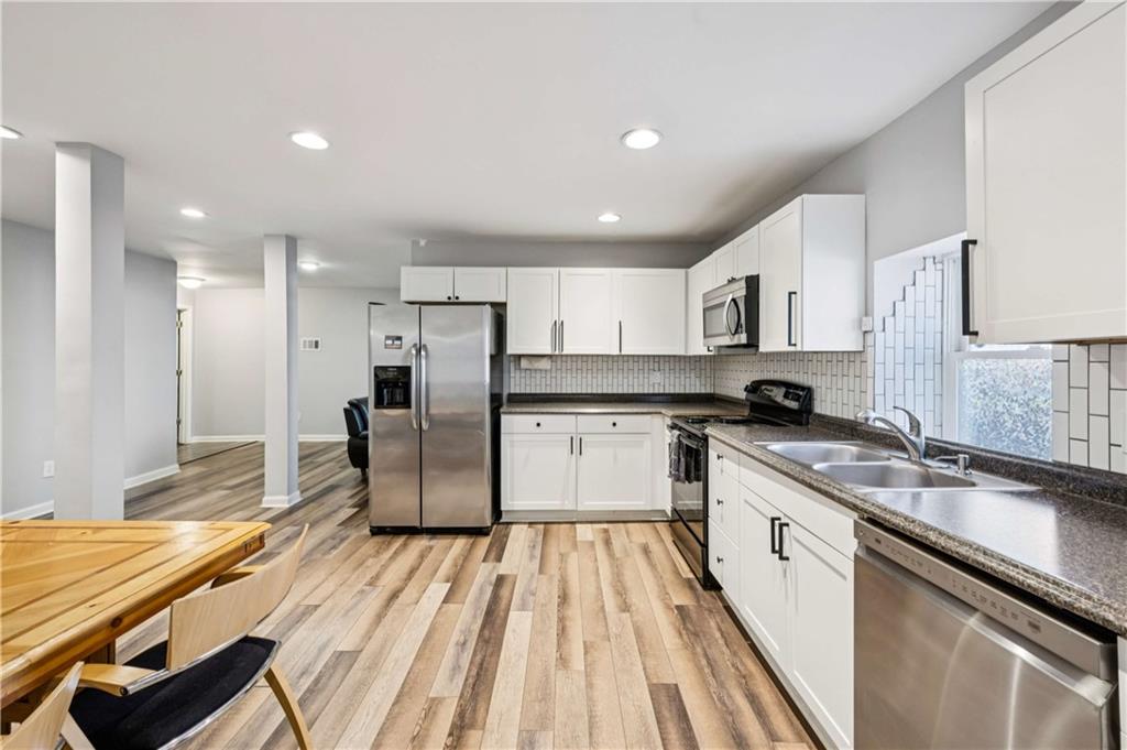528 Holderness Street Southwest Atlanta, GA 30310 - Photo 26 of 42 a large kitchen with stainless steel appliances kitchen island granite countertop a sink and cabinets