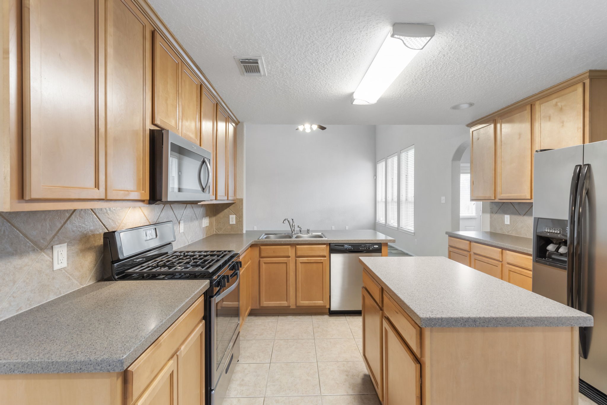 21810 Colter Stone Drive Spring, TX 77388 - Photo 32 of 33 a kitchen with a stove a sink and a refrigerator