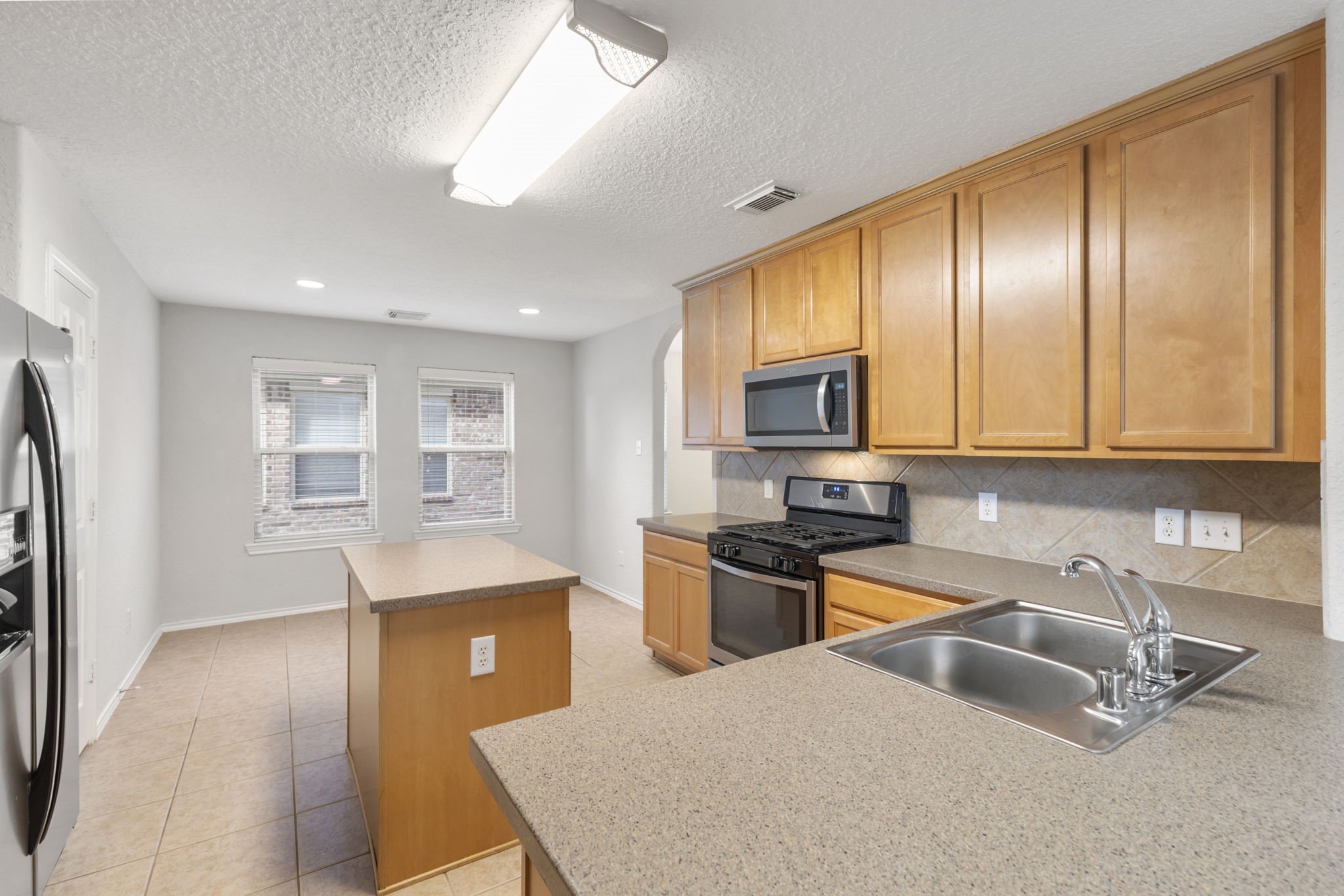 21810 Colter Stone Drive Spring, TX 77388 - Photo 13 of 33 a kitchen with stainless steel appliances granite countertop a sink dishwasher stove and refrigerator with wooden floor