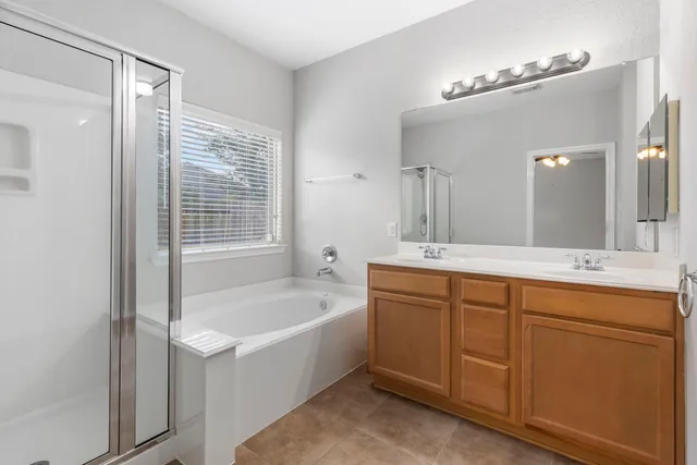 a bathroom with a tub sink and mirror