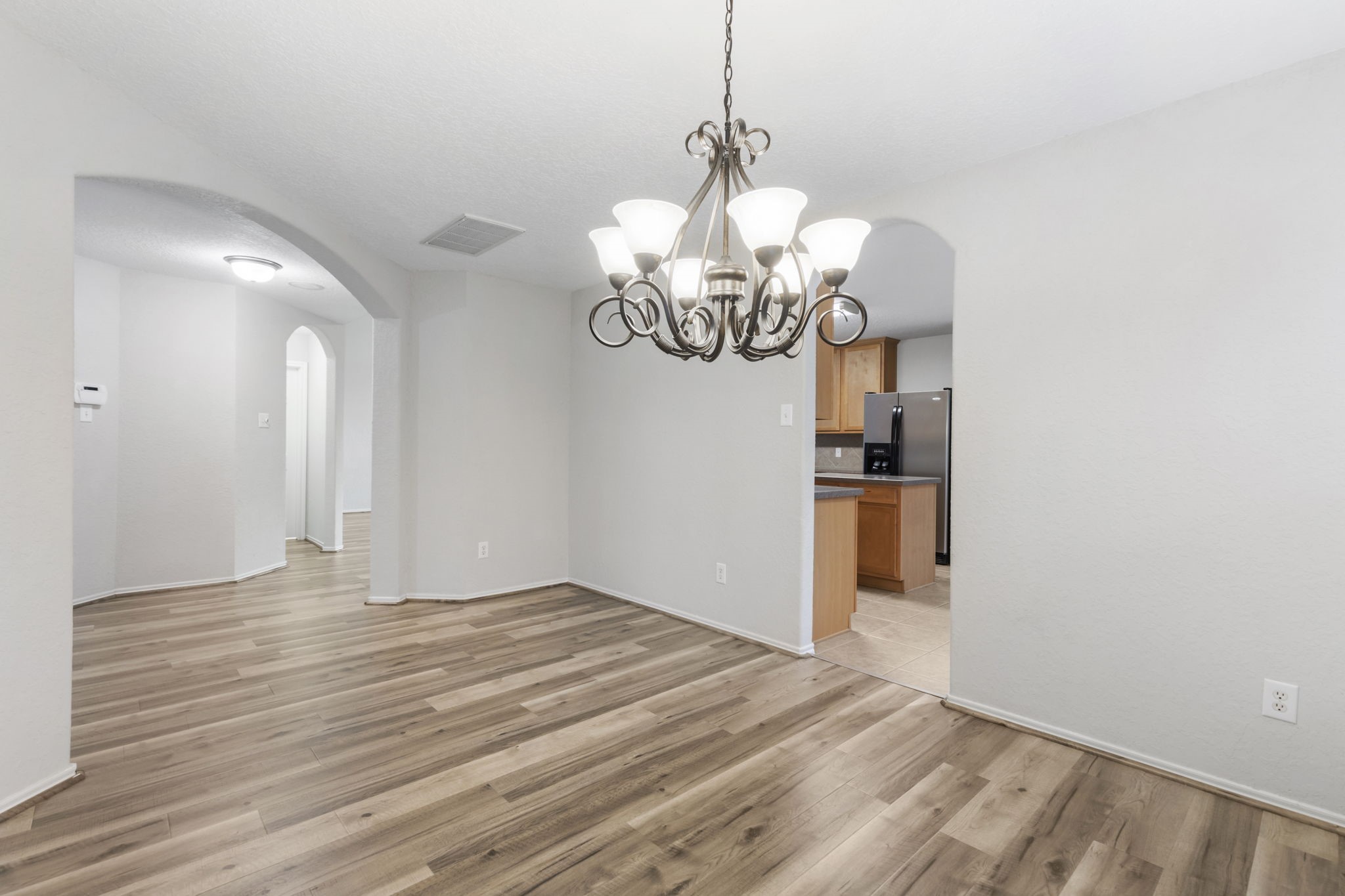 21810 Colter Stone Drive Spring, TX 77388 - Photo 10 of 33 a view of a chandelier in big room with wooden floor