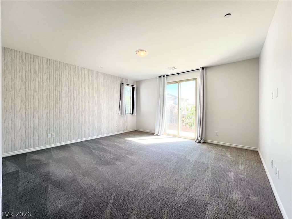925 Bayberry Ridge Street Henderson, NV 89052 - Photo 14 of 27 A spacious chamber with soft carpeting, large sliding doors leading to an outdoor view, and a single window for additional light.
