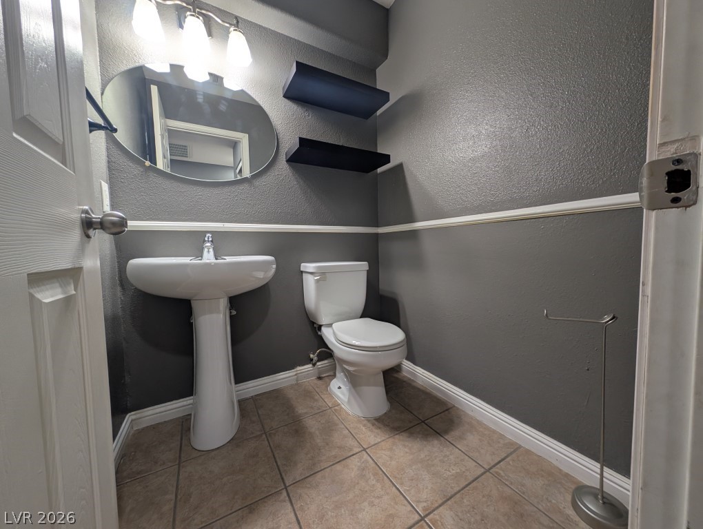 9121 Spoonbill Ridge Place Las Vegas, NV 89143 - Photo 7 of 26 Step into a well-appointed guest bathroom featuring a pedestal sink and tile flooring.