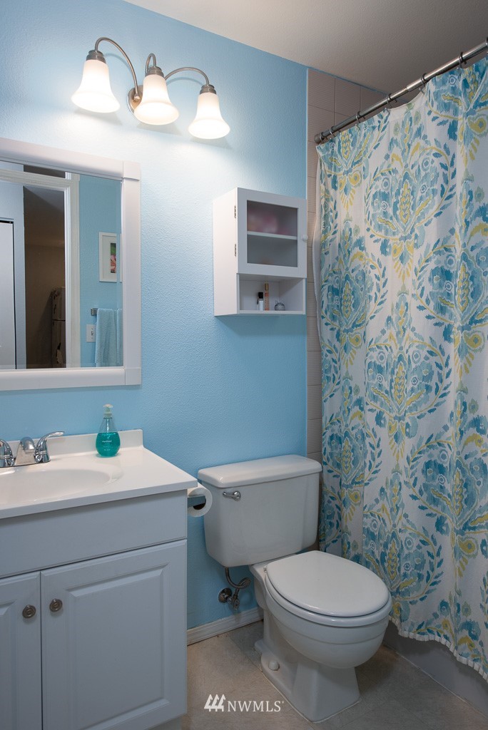 2152 North 112th Street, Unit 303 Seattle, WA 98133 - Photo 12 of 19 a bathroom with a toilet a sink and mirror