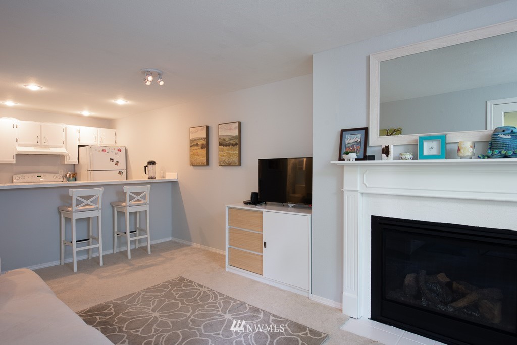 2152 North 112th Street, Unit 303 Seattle, WA 98133 - Photo 7 of 19 a livingroom with furniture a fireplace and a flat screen tv