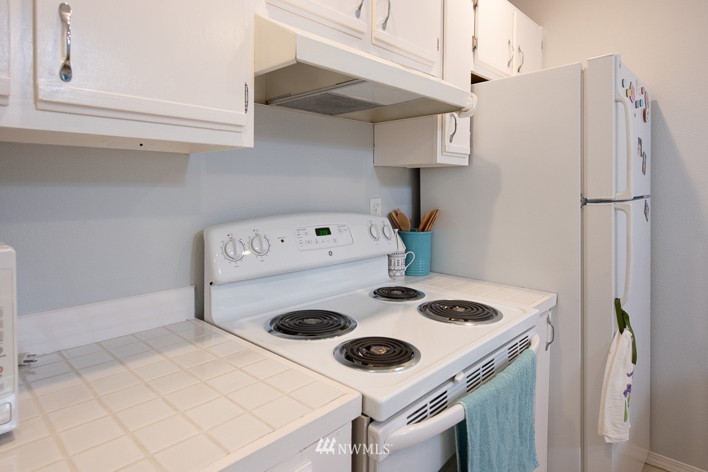 2152 North 112th Street, Unit 303 Seattle, WA 98133 - Photo 10 of 19 a kitchen with a stove and a refrigerator