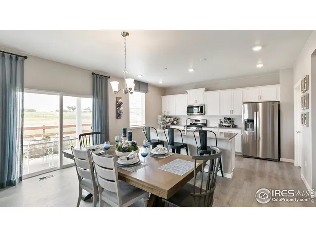 a dining room with stainless steel appliances kitchen island granite countertop a table chairs and couches with kitchen view