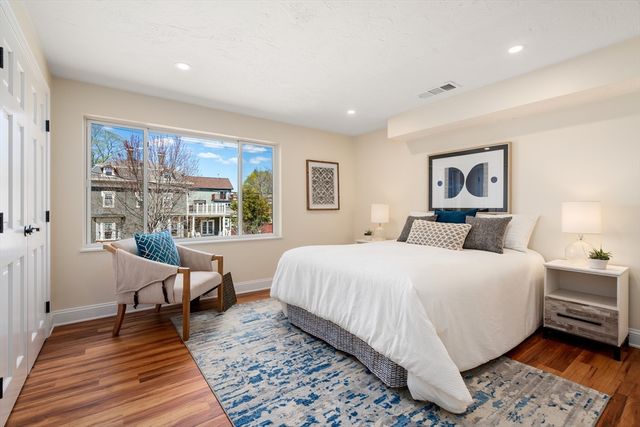 a bedroom with a large bed a rug and a window