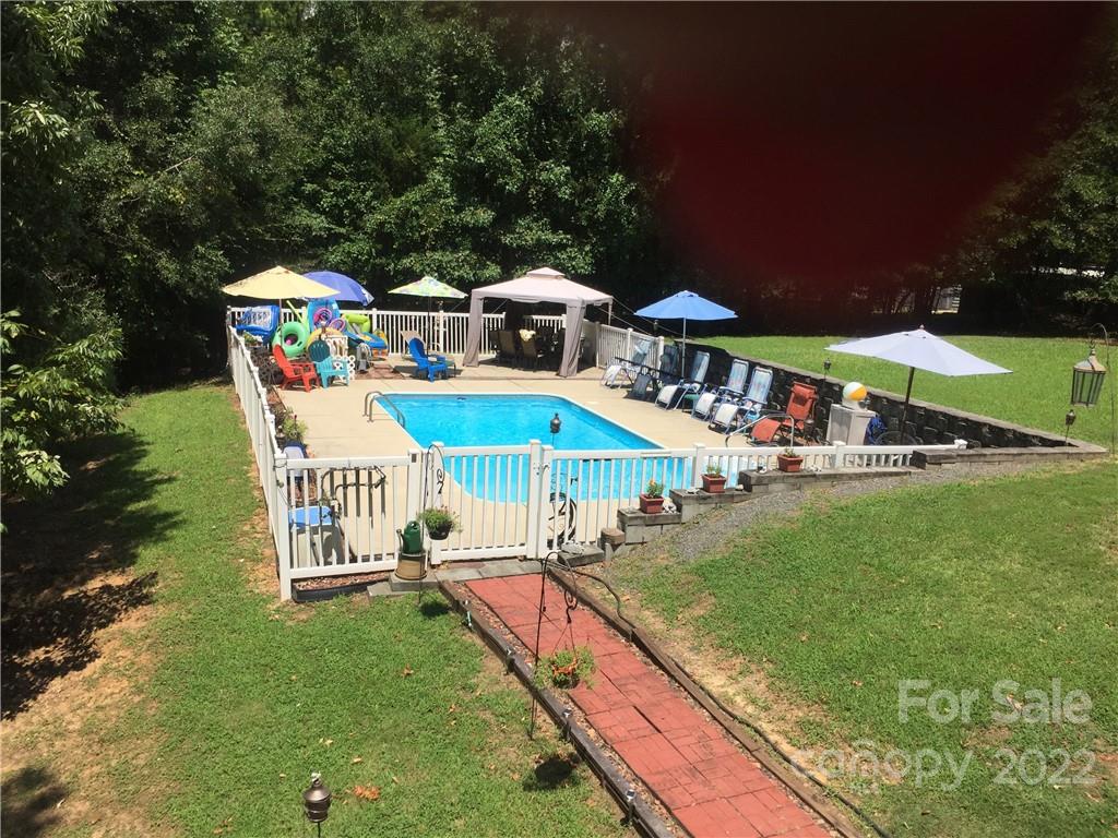 25030 Riley Lane Tega Cay, SC 29708 - Photo 1 of 48 a view of a patio with a table and chairs under an umbrella