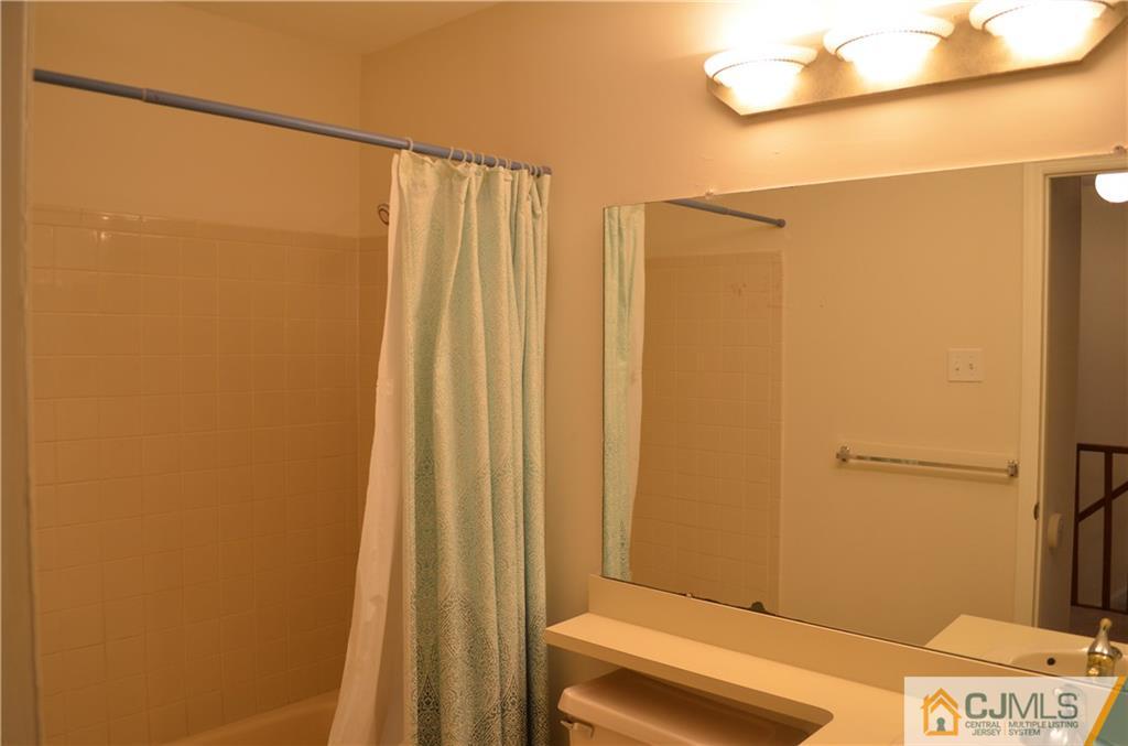 225 Constitution Circle North Brunswick, NJ 08902 - Photo 17 of 17 a bathroom with a shower curtain and a sink