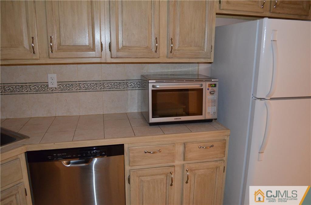 225 Constitution Circle North Brunswick, NJ 08902 - Photo 3 of 17 a kitchen with stainless steel appliances white cabinets and a refrigerator