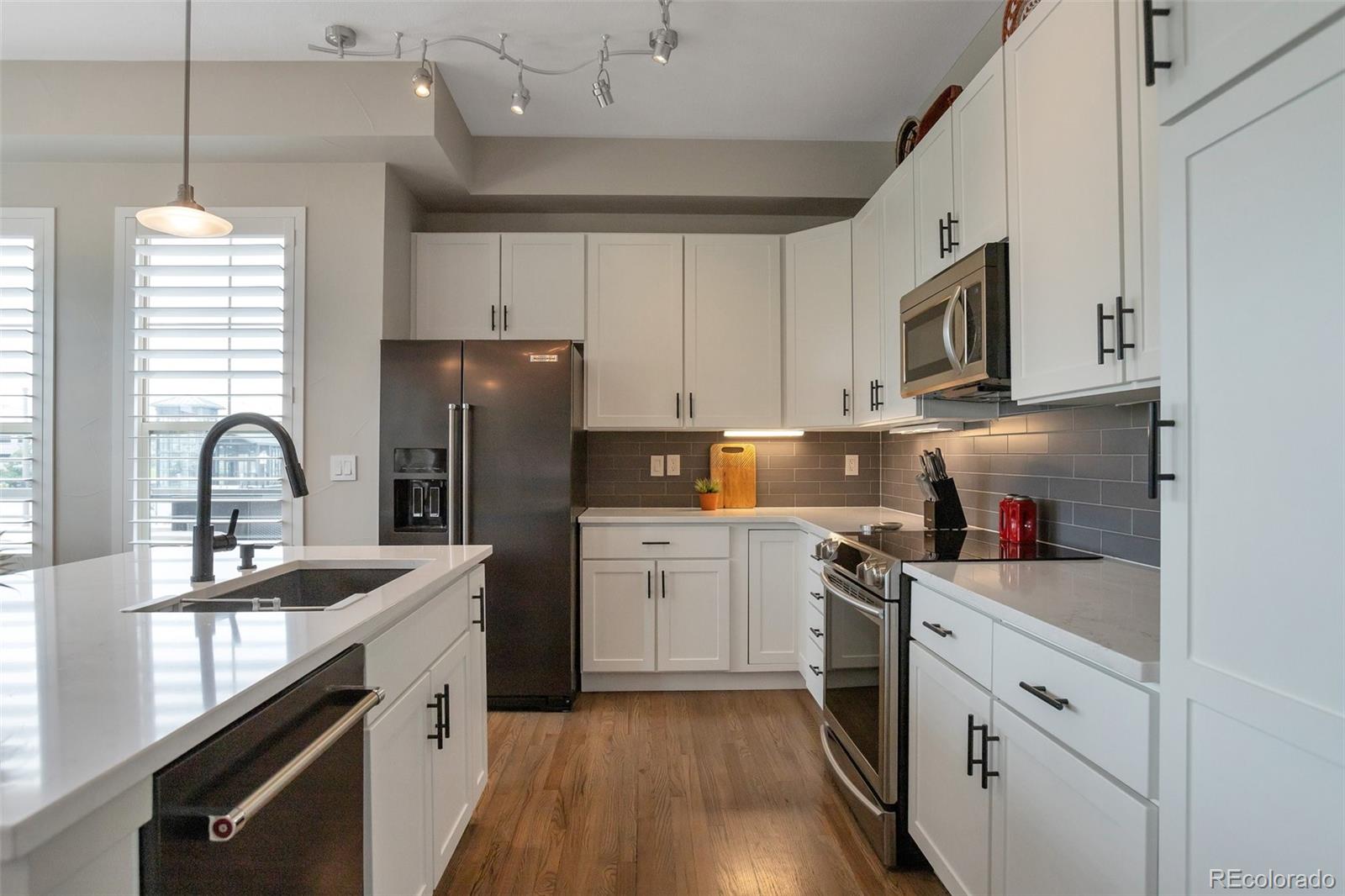 10111 Inverness Main Street, Unit 301 Englewood, CO 80112 - Photo 4 of 28 a kitchen with stainless steel appliances granite countertop a sink dishwasher a refrigerator and a stove