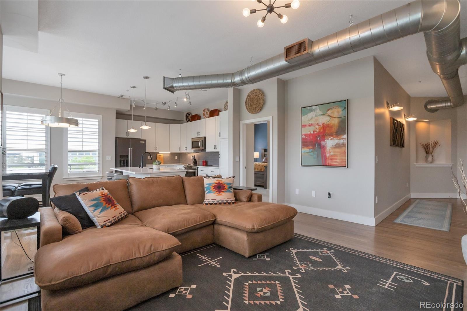 10111 Inverness Main Street, Unit 301 Englewood, CO 80112 - Photo 6 of 28 a living room with furniture and a rug