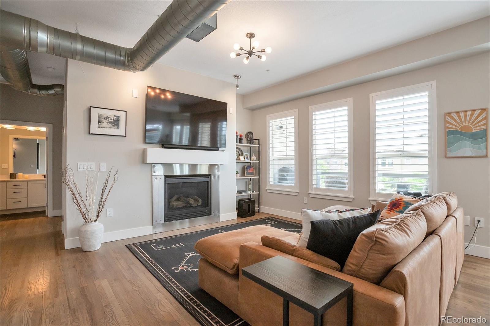 10111 Inverness Main Street, Unit 301 Englewood, CO 80112 - Photo 9 of 28 a living room with furniture a flat screen tv and a fireplace