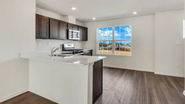a kitchen with stainless steel appliances granite countertop a stove a sink and a microwave