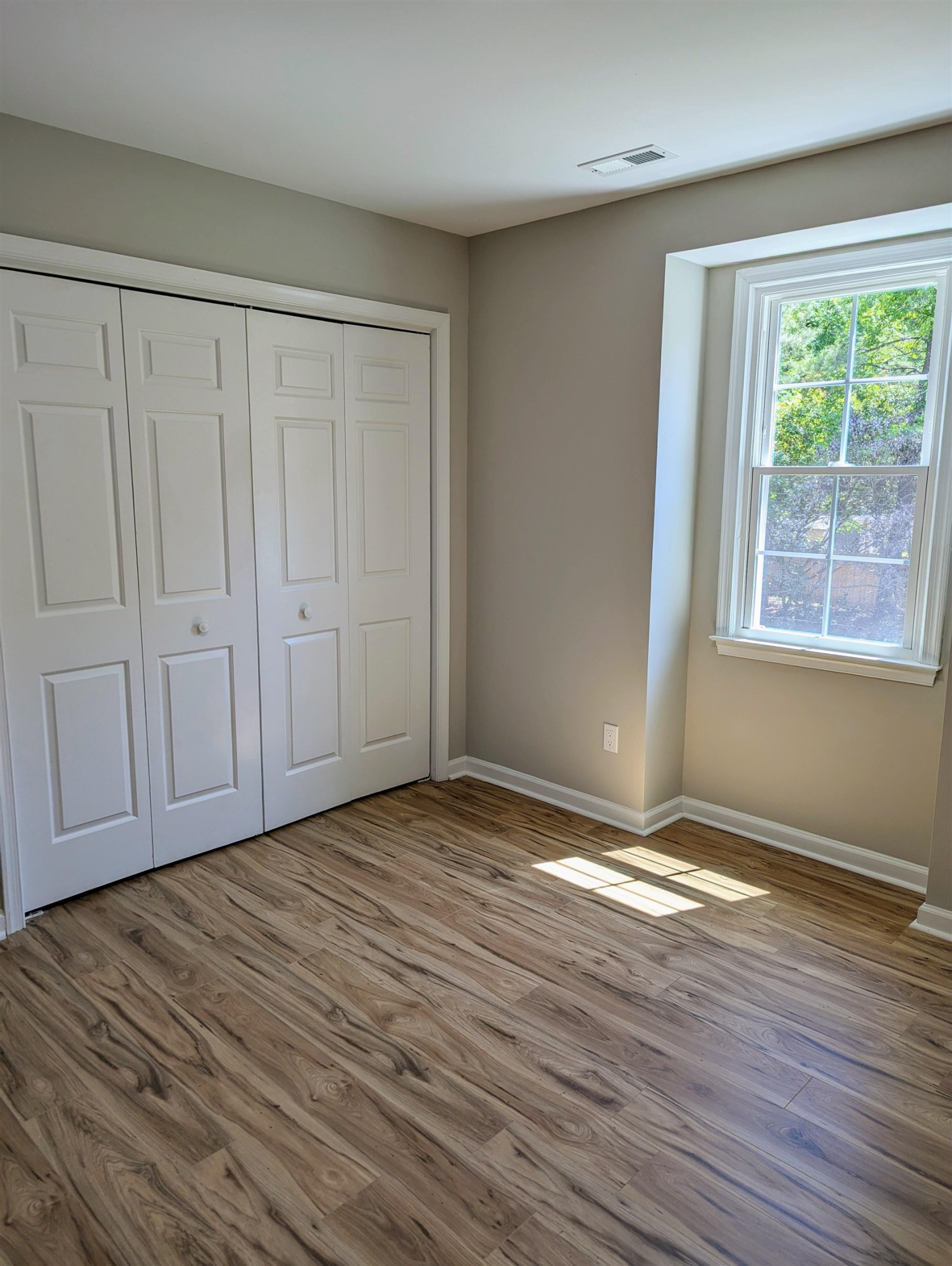 2 Austin Court Durham, NC 27707 - Photo 20 of 29 a view of an empty room with wooden floor and a window