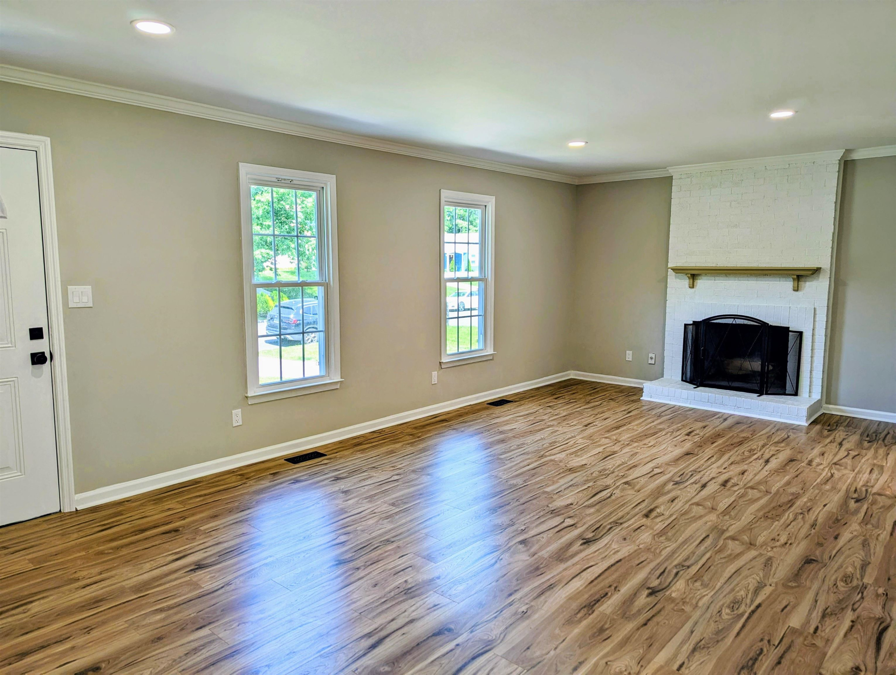 2 Austin Court Durham, NC 27707 - Photo 6 of 29 an empty room with wooden floor a fireplace and windows