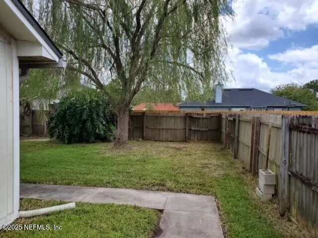 a view of a backyard with barn and large trees