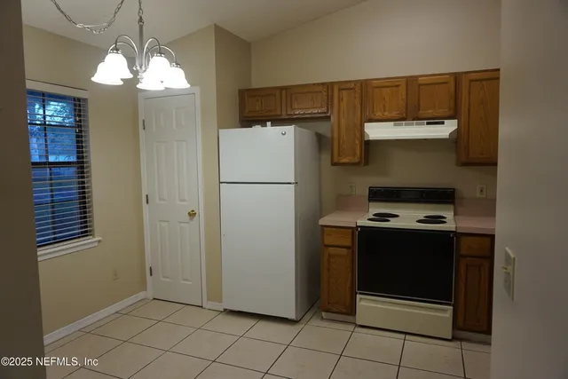 a kitchen with a refrigerator and a stove top oven